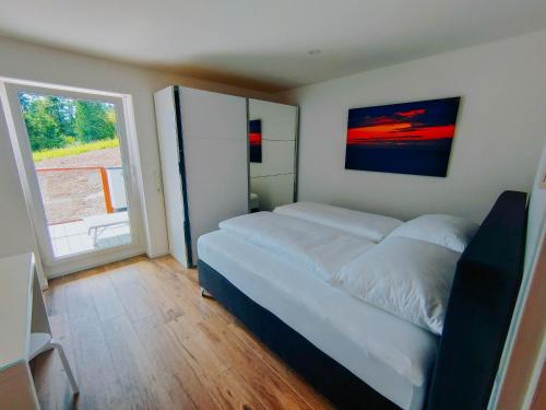 a bedroom with a large bed and a large window at Downhill Lodge Tauplitz in Tauplitz