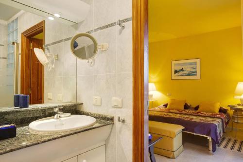 ein Bad mit einem Waschbecken und ein Bett in einem Zimmer in der Unterkunft VCV Villa Magua in Santa Brígida