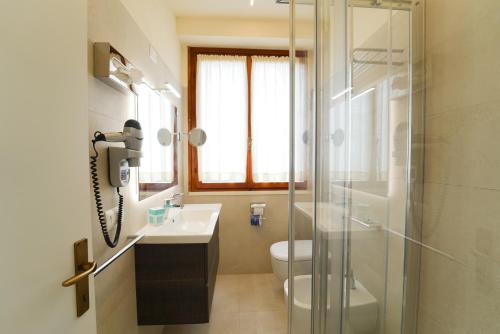 a bathroom with a sink and a toilet and a phone at Residence Le Acacie in Capoliveri