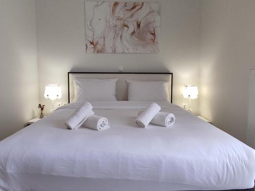 a white bed with three pillows on top of it at Central & Comfortable, with Acropolis view in Athens