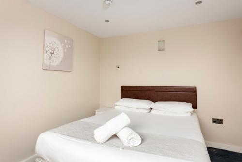 a bedroom with a bed with two towels on it at The R Inn Hotel in Desborough