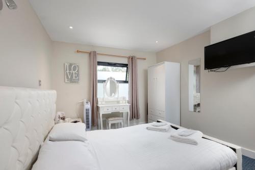 a bedroom with two beds and a mirror at The R Inn Hotel in Desborough