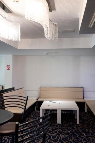 a waiting room with benches and a table and chairs at The R Inn Hotel in Desborough