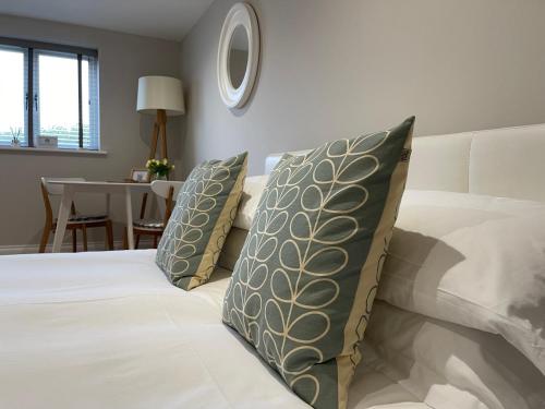 a bedroom with a bed with pillows and a table at No 12 Furze Croft in St Ives