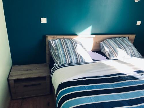 - une chambre bleue avec un lit et une table de nuit dans l'établissement Maison de charme et accueillante, à Chalifert