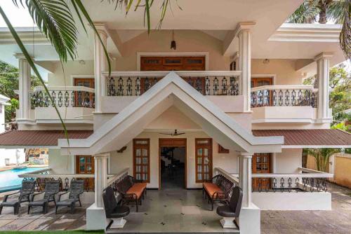 a house with a balcony and a swimming pool at Villa Calangute Phase 1 in Calangute