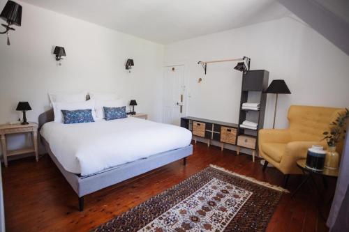 a bedroom with a white bed and a chair at Demeure du Haut Canteloup in Honfleur