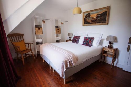 a bedroom with a white bed and a chair at Demeure du Haut Canteloup in Honfleur