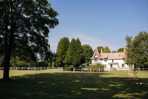 a large field with a house and a white fence at Demeure du Haut Canteloup in Honfleur