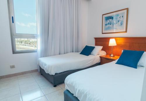 Almog Beach Apartments מגדלי חוף הכרמל חיפהにあるベッド