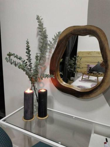 a table with two candles and a mirror on it at HINODE Geniehome 3BR free WIFI and CARPARK at Utropolis Shah Alam in Shah Alam