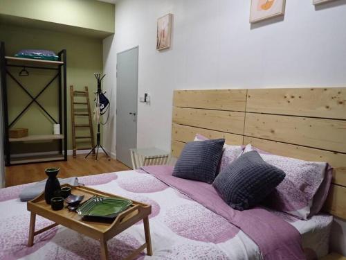 a bedroom with a large bed with a wooden headboard at HINODE Geniehome 3BR free WIFI and CARPARK at Utropolis Shah Alam in Shah Alam