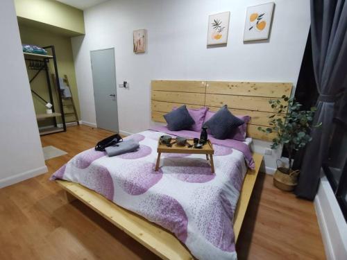 a bedroom with a large bed with a table at HINODE Geniehome 3BR free WIFI and CARPARK at Utropolis Shah Alam in Shah Alam