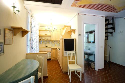a kitchen with a table and a tv in a room at Residence Le Acacie in Capoliveri