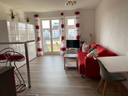 a living room with a red couch and a television at Apartment- Singen Überlinger Straße in Singen