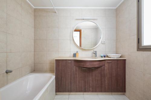 y baño con bañera, lavabo y espejo. en A white dream by the sea - 2bd lux family apartment en Herzliyya B