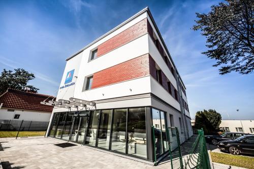 a large building with glass doors in a parking lot at Dom Żeglarza in Puck