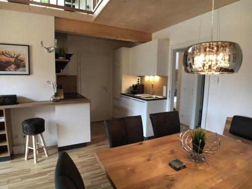 een eetkamer en een keuken met een houten tafel en stoelen bij Leben!Pur - Alpenlofts in Bad Mitterndorf