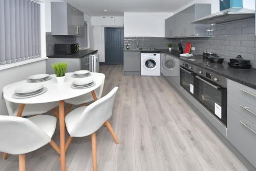 a kitchen with a white table and chairs at Townhouse @ 24 Brunswick Place Stoke in Etruria