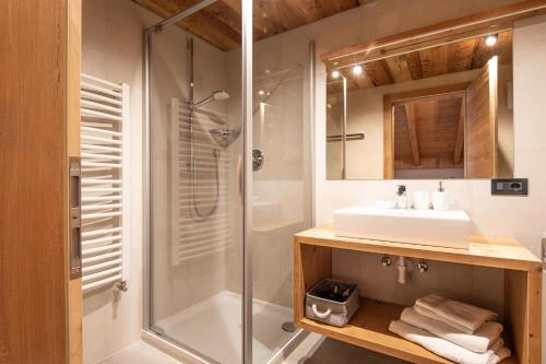 a bathroom with a glass shower and a sink at Appartamenti La Munt in Badia