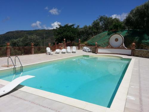 a large swimming pool with chairs at L'Uliveto in Reitano