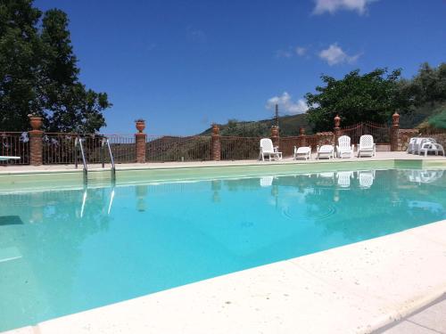 a swimming pool with chairs and a water slide at L'Uliveto in Reitano