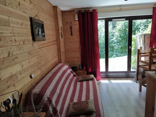 a bedroom with a bed in a room with wooden walls at appart st gervais le Topaze in Saint-Gervais-les-Bains