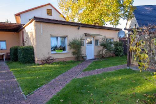 a house with a brick pathway in front of a yard at Ferien am Bierbach in Eldena