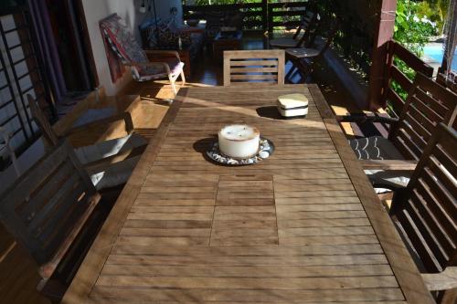a wooden table on a porch with a cake on it at ECOVILLA CORAL GARDEN in Baoruco