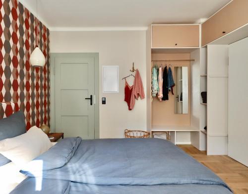 - une chambre avec un lit bleu et un placard dans l'établissement Ferienwohnung 60er Jahre Design Apartment - 65qm Fewo im Zittauer Gebirge - familienfreundliche Unterkunft am Bergfuß zum Töpfer, à Olbersdorf