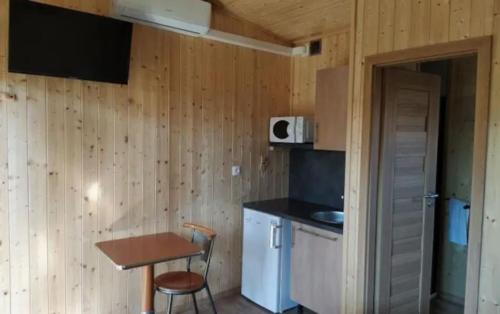 a small kitchen with a table and a small table and a chair at Domaine des Epinettes in Saint-Romain-de-Jalionas