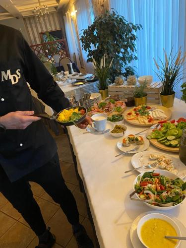 a man holding a plate of food on a table at MDS Wielichowo in Wielichowo