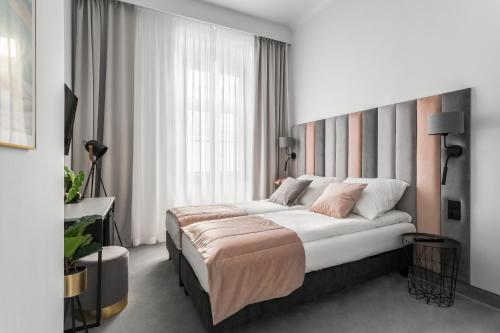 une chambre avec un lit et une grande fenêtre dans l'établissement Old Town Residence - Premium Aparthotel, à Cracovie