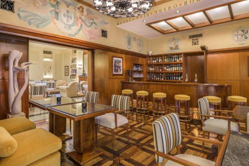 a restaurant with a bar with chairs and tables at Hotel Britania Art Deco - Lisbon Heritage Collection - Avenida in Lisbon