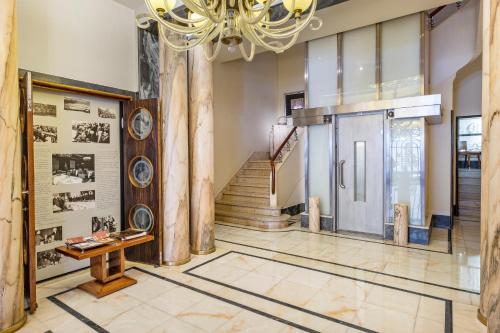 a hallway with a staircase and a door with a chandelier at Hotel Britania Art Deco - Lisbon Heritage Collection - Avenida in Lisbon