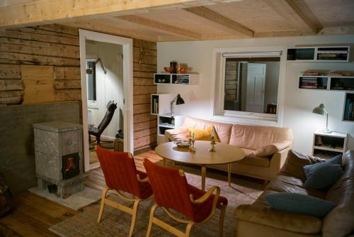 sala de estar con sofá, mesa y chimenea en Most photographed house in Reine, en Reine