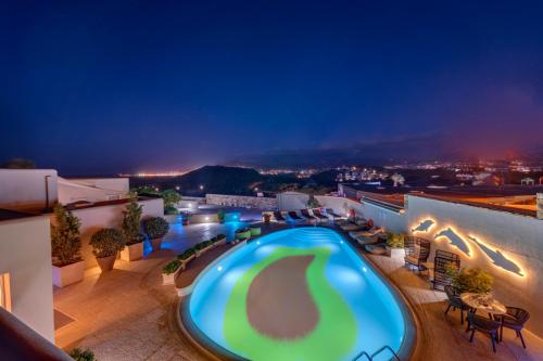 a pool on the roof of a building at night at Kouros Art Hotel - Designed for Adults in Stelida