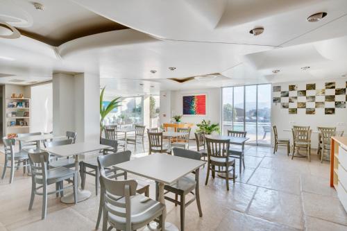 un restaurant avec des tables, des chaises et des fenêtres dans l'établissement Kouros Art Hotel (Adults Only), à Stelida