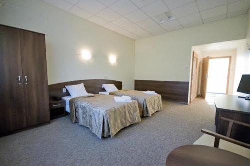 a hotel room with two beds and a desk at Hotel A4 MOP Kępnica in Jaworzno