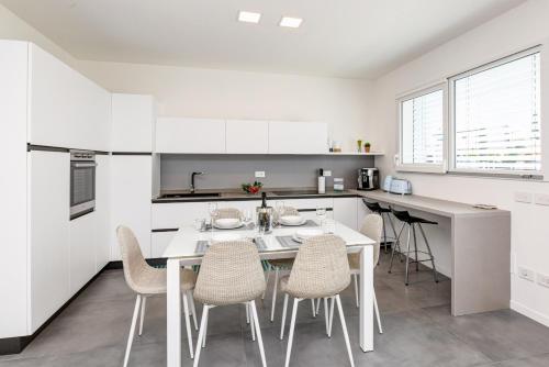 a white kitchen with a table and chairs at Villette Dolci Luxury Homes in Peschiera del Garda