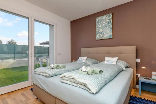 2 camas en un dormitorio con ventana grande en Villette Dolci Luxury Homes, en Peschiera del Garda