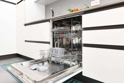 a dishwasher in a kitchen with white cabinets at Villette Dolci Luxury Homes in Peschiera del Garda