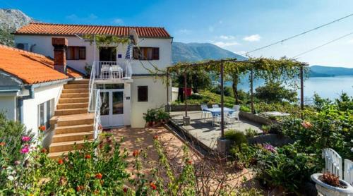 ein weißes Haus mit Blick auf das Wasser in der Unterkunft Guest House Fontana in Mlini