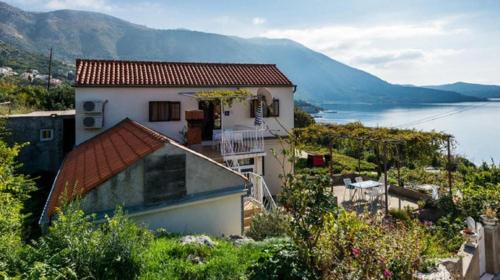 a house sitting on top of a hill next to a body of water at Guest House Fontana in Mlini