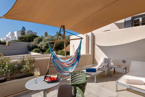 a hammock on the balcony of a house at Kouros Art Hotel - Designed for Adults in Stelida