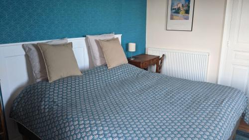 Saint-Cirgues-de-Jordanne的住宿－La Maison Normande，一间卧室配有一张带蓝色床单和枕头的床。