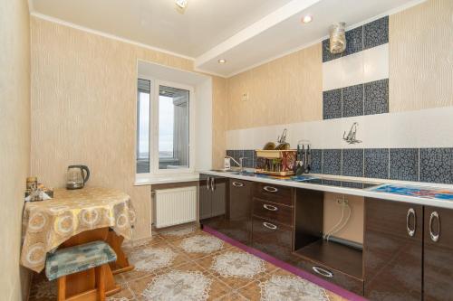 una cocina con fregadero y mesa. en Apartments na Lenina 142 en Magnitogorsk