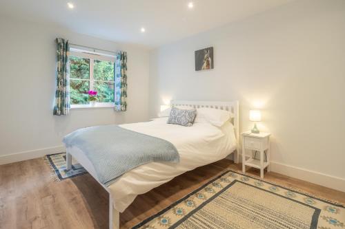 A bed or beds in a room at Secluded cottage in pretty countryside with woods & walks - Bradleys Barn