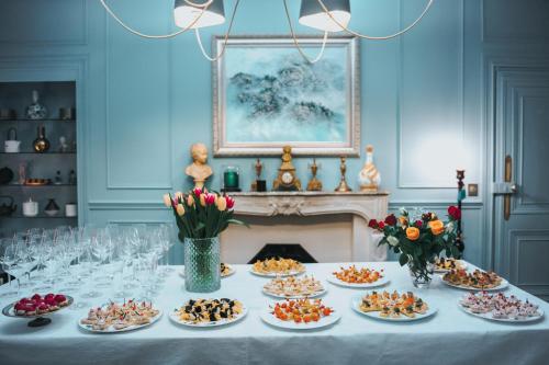 a table with many plates of food on it at CHATEAU DE BRINVILLE in Saint-Sauveur-sur-École
