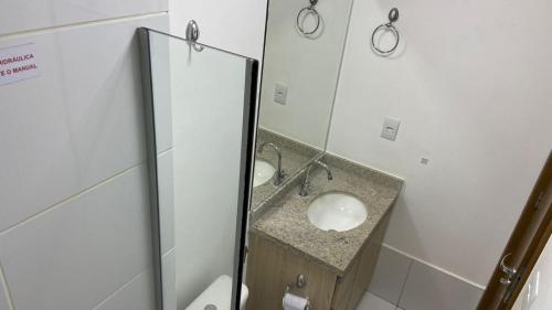 a bathroom with two sinks and a mirror at Trend 2414 in Goiânia